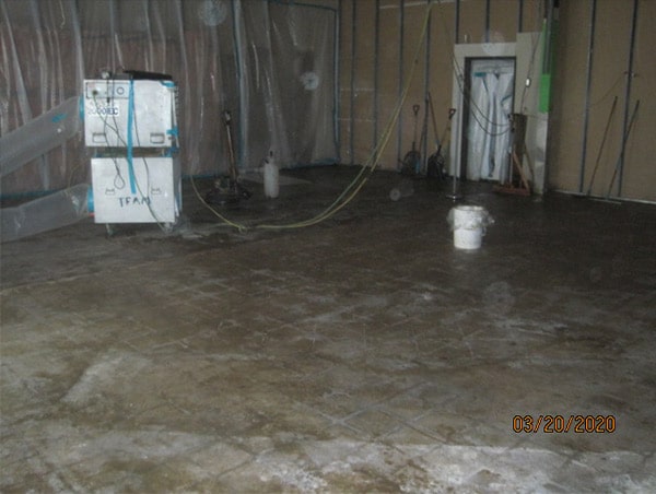 Another photo of floor in a room of home in a asbesotos remediation project supervised by Precision Environmental Services. Asbestos removal equipment is shown on the left hand side of the photo.