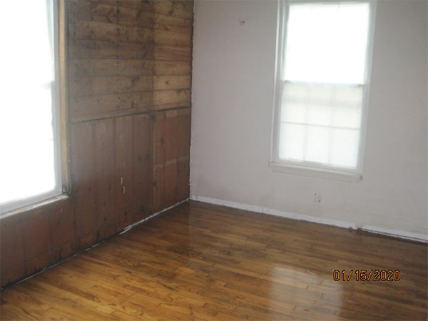 Photo of interior room of a home with hardwood floor in an asbesotos removal project overseen by Precision Environmental Services.
